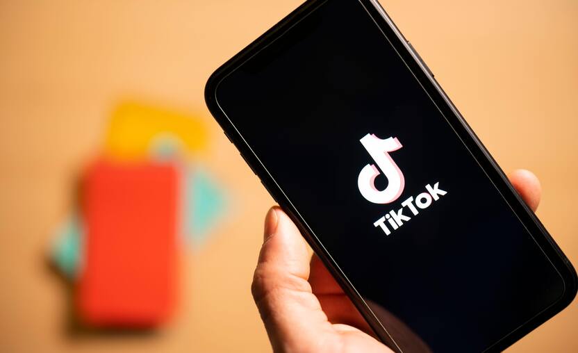 Rome, Italy, 24 January 2021. Overhead shot of a human hand holding a smartphone with the TikTok logo.