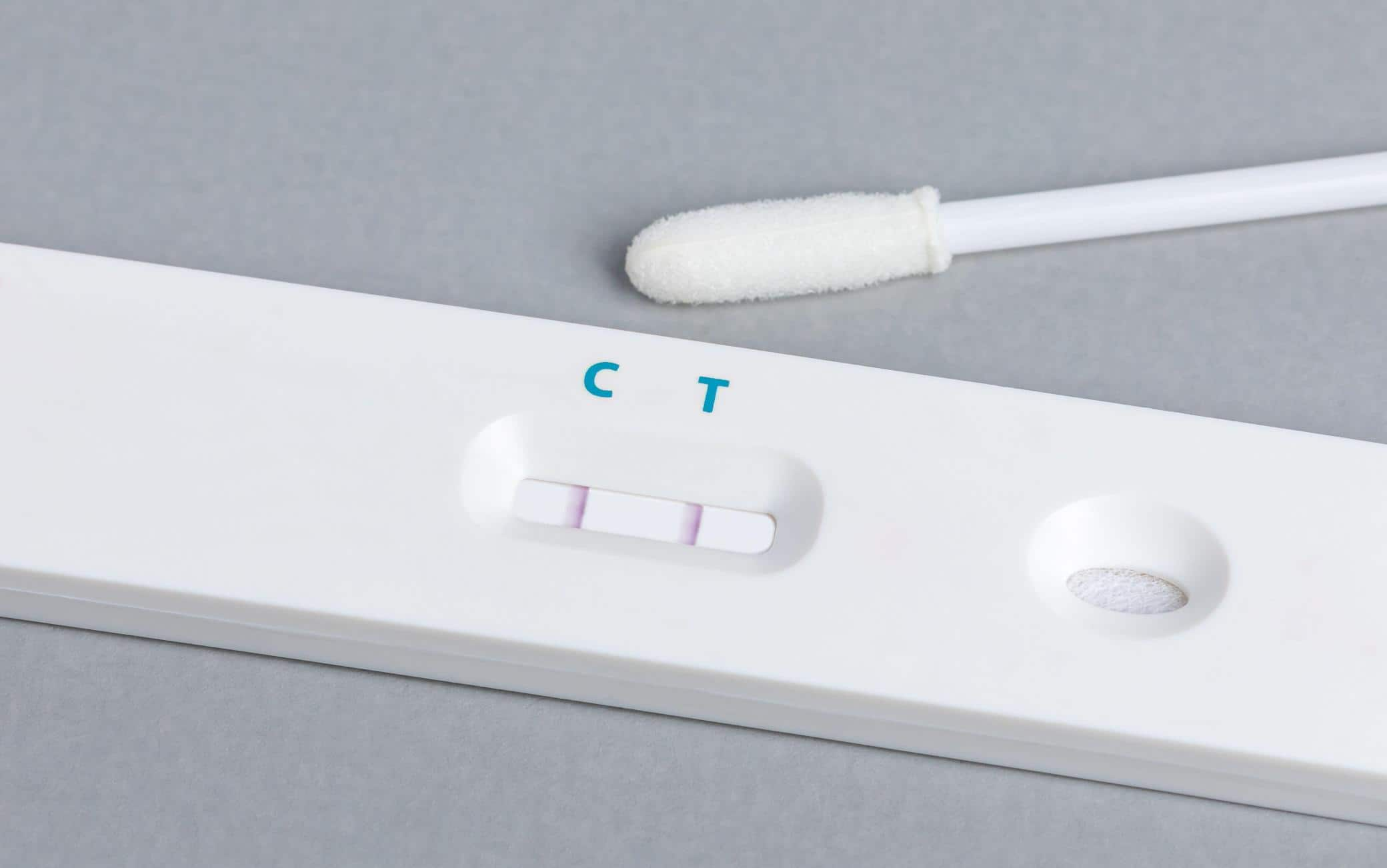 Covid-19 rapid test kit with positive result. Coronavirus home testing, pandemic and healthcare concept.