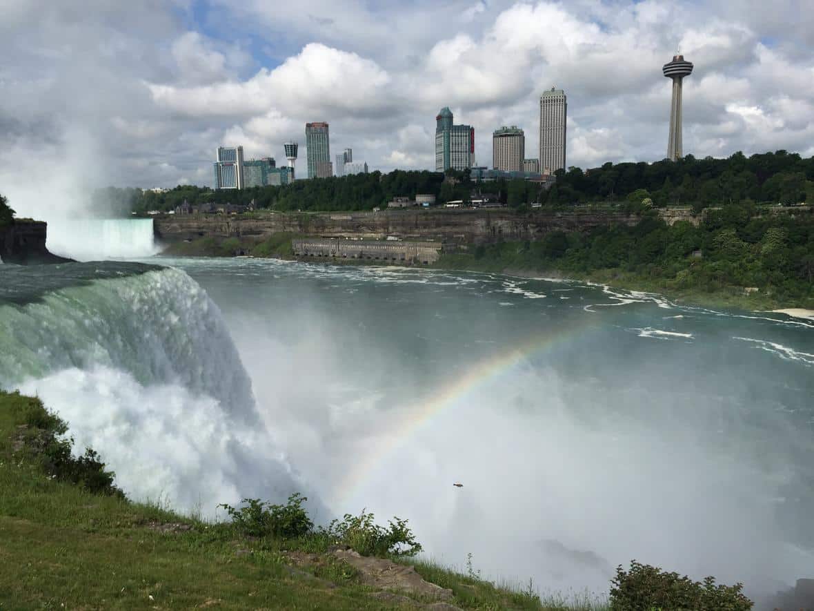 A rainbow appears in the spray from a waterfall. A view of American Falls from the United States side of Niagara Falls. Photo: Alex Demas, USGS. Public domain.