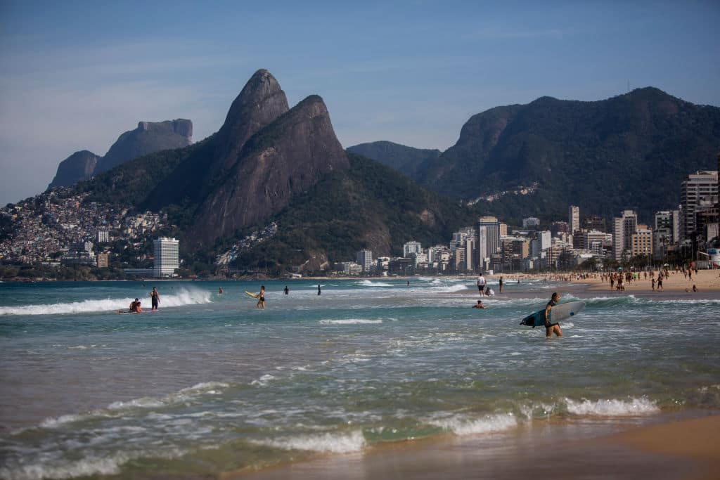 RIO DE JANEIRO, BRAZIL - JULY 12: People enjoy the weather at Arpoador Beach amidst the coronavirus (COVID-19) pandemic on July 12, 2020 in Rio de Janeiro, Brazil. The practice of physical activities on boardwalks and individual sports at sea is allowed. However, the use of chairs and tents on the sand is still prohibited. Mayor Marcelo Crivella warned of the intensification of inspection and the imposition of a fine for those who do not comply with the rules. (Photo by Bruna Prado/Getty Images)