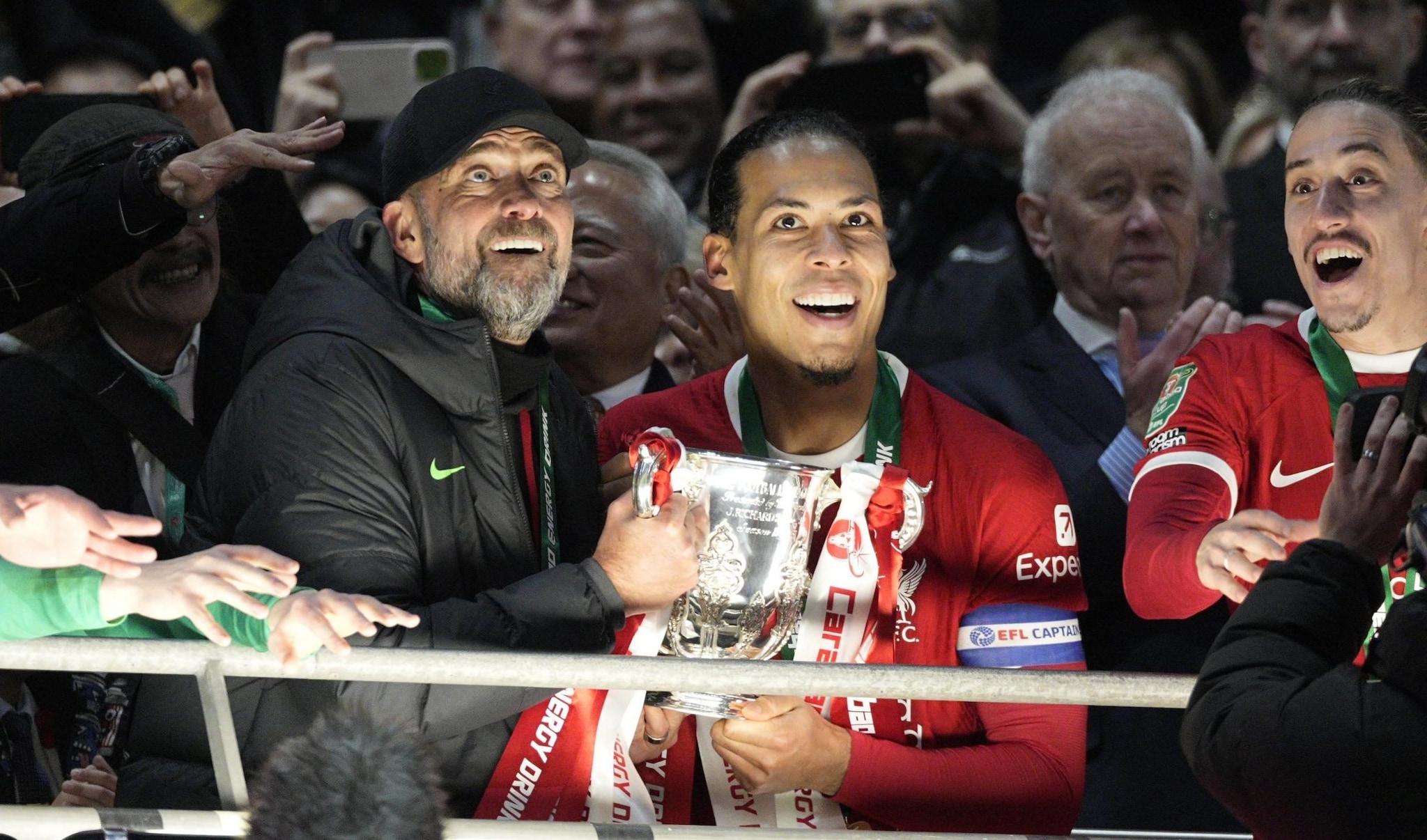 Van Dijk solleva il trofeo della Coppa di Lega inglese assieme al tecnico, Klopp.