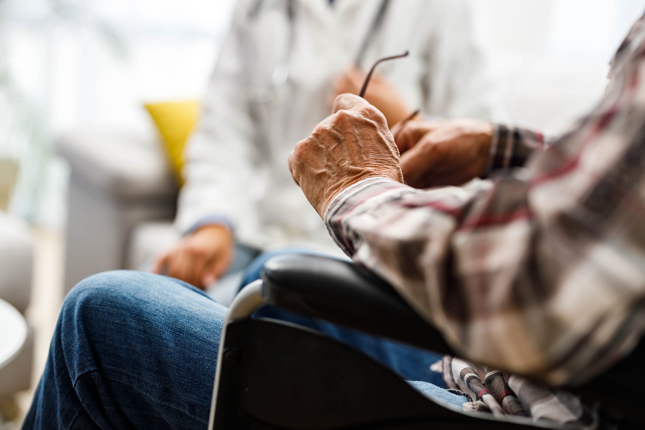 Close up of unrecognizable mature man in a wheelchair at nursing home.