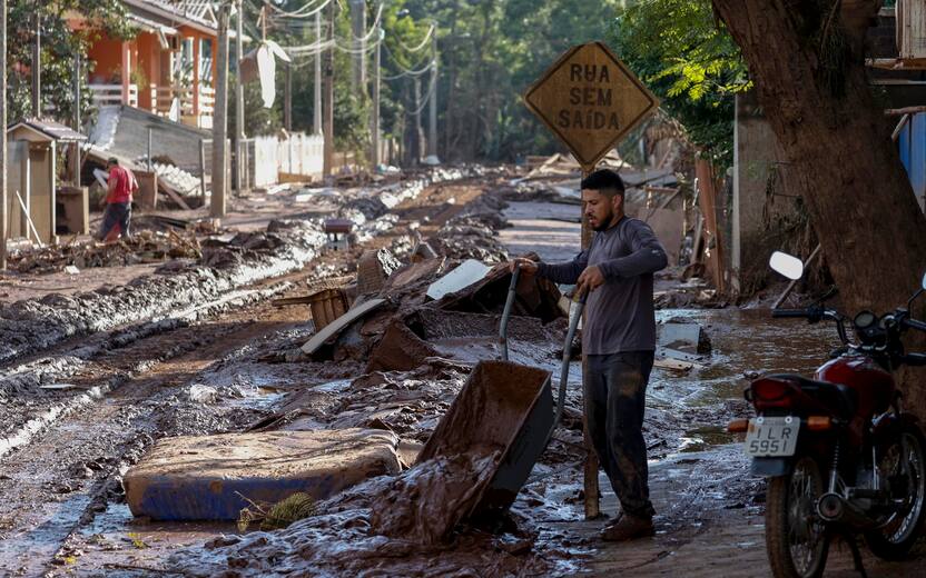 epaselect epa11327657 A man removes the mud that flooded his house after the Taquari river overflowed its banks in Cruzeiro do Sul, Rio Grande do Sul state, Brazil, 08 May 2024. The death toll from catastrophic floods in southern Brazil has exceeded 100, according to the latest figures released by the Civil Defense on 08 May. EPA/SEBASTIAO MOREIRA