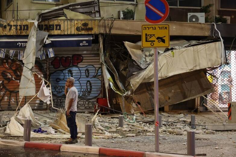 TOPSHOT - A man stands in front of a damaged shop in Tel Aviv, after it was hit by a rocket fired by Palestinian militants from the Gaza Strip on October 7, 2023. Palestinian militant group Hamas launched a surprise large-scale attack against Israel on October 7, firing thousands of rockets from Gaza and sending fighters to kill or abduct people as Israel retaliated with devastating air strikes. (Photo by JACK GUEZ / AFP) (Photo by JACK GUEZ/AFP via Getty Images)