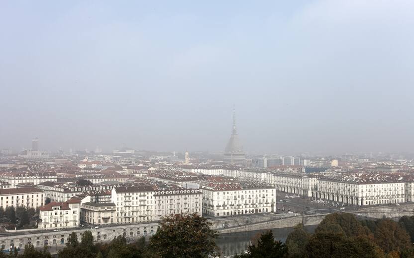 Daytime panorama of the city of Turin, Italy, in a foggy day. River Po is in the foreground, Mole Antonelliana (iconic monument of the city) can be barely seen.