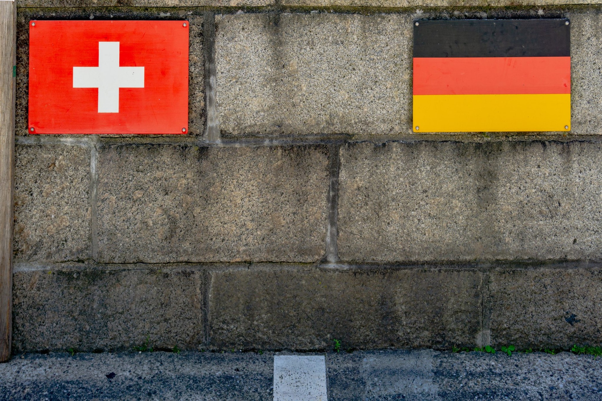 Valico di frontiera dalla Svizzera alla Germania con bandiere e linea sul ponte di Laufenburg.