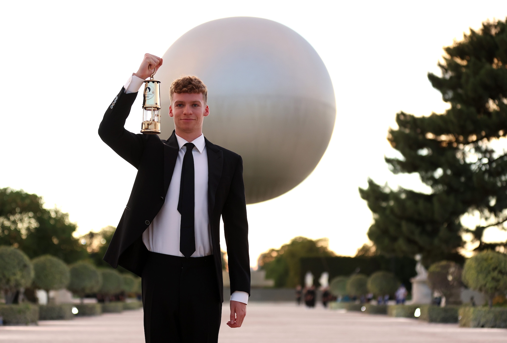 Leon Marchand con la fiamma olimpica nel Giardino delle Tuileries