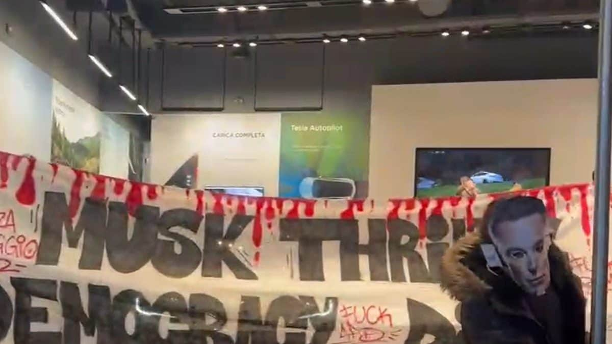 Lo striscione esposto all'interno del negozio Tesla di Milano (frame da video di Beatrice Barra - Fanpage.it)